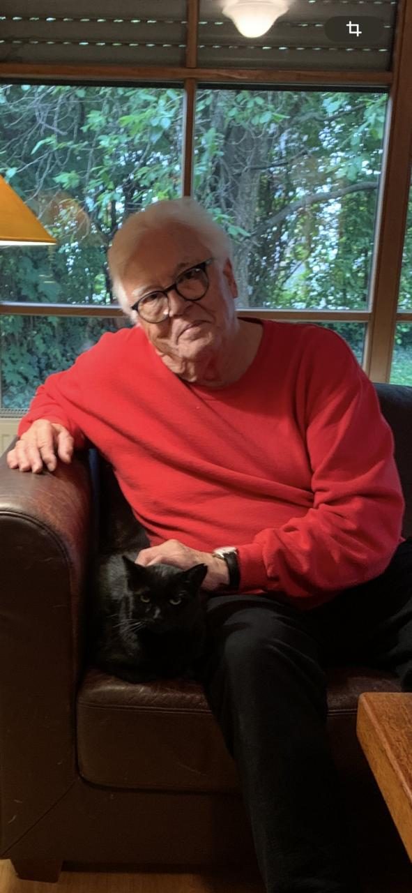 Elderly man with adopted black cat on his lap